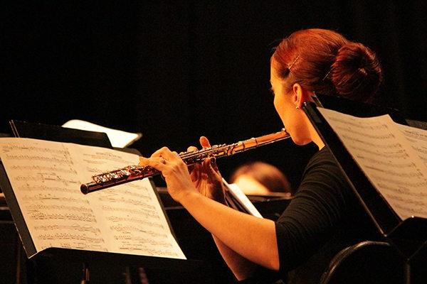 Female student plays music on a flute